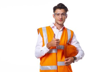 Turuncu üniformalı bir adam inşaat işinde.