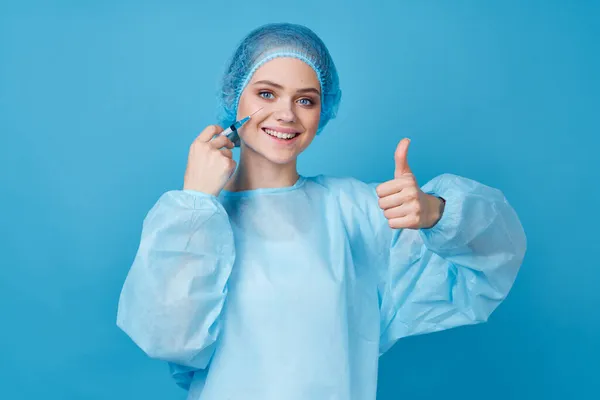 Médico en ropa protectora tratamiento hospital fondo azul — Foto de Stock
