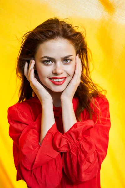 Усміхнена жінка в червоній сукні позує жовтий фон — стокове фото