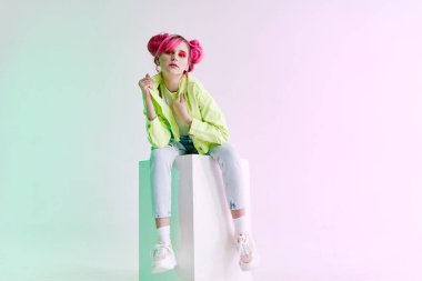 Pembe saçlı, hipster neon pozu veren çekici, şık bir kadın.