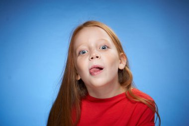 neşeli kızıl saçlı kız çocukluk mavi arka planı