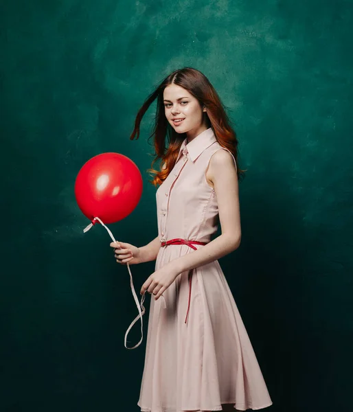 Bonita mulher no vestido vermelho balão férias verde fundo — Fotografia de Stock