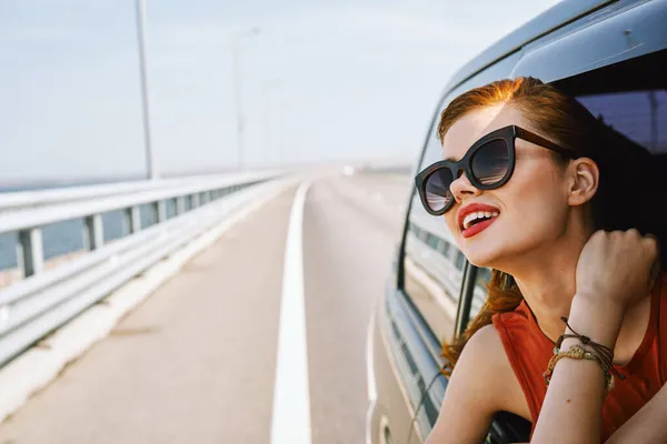 Hübsche Frau mit Sonnenbrille fährt im Reiseauto — Stockfoto