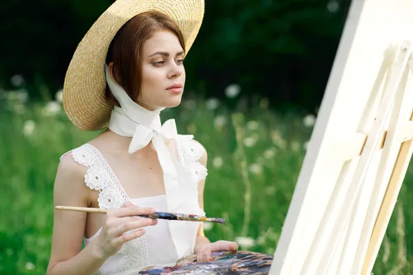 Kadın ressam görünümlü boya paleti doğada bir resim çizer. — Stok fotoğraf