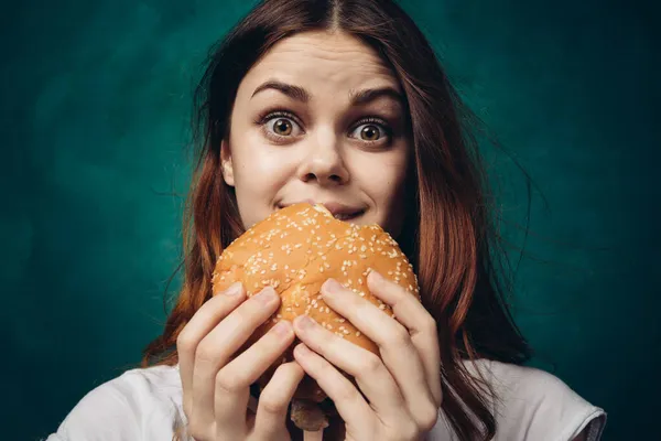 Žena jíst hamburger rychlé občerstvení zblízka — Stock fotografie