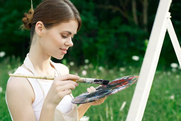Woman artist paints palette easel nature drawing — Stock Photo, Image