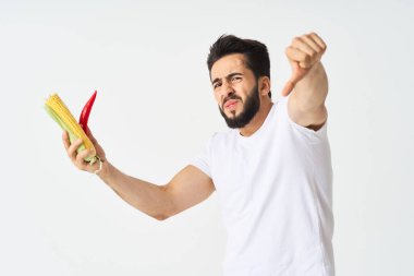 Elinde sebzelerle sakallı bir adam. Sıcak biberli mısır.