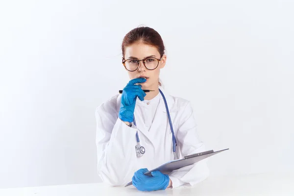 파란 장갑 약물 검사를 받고 테이블에 앉아 있는 여성 의사 — 스톡 사진