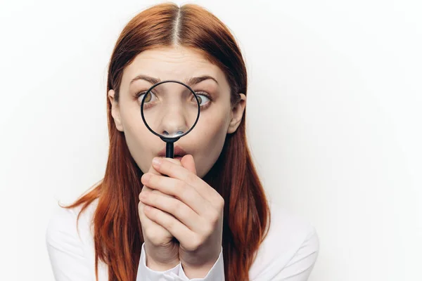 Jolie femme grimacant avec loupe près du visage — Photo