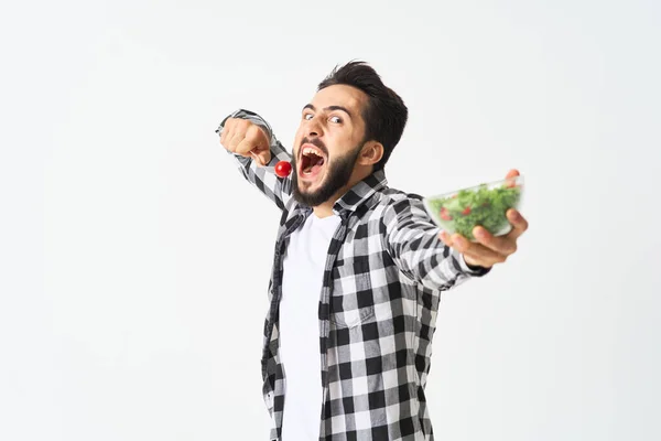Homem barbudo emocional em prato de camisa xadrez com salada — Fotografia de Stock