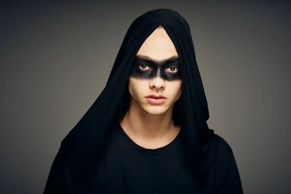 검은 마스크를 쓴 남자가 어두운 배경의 유령 의상을 입고 있다 — 스톡 사진