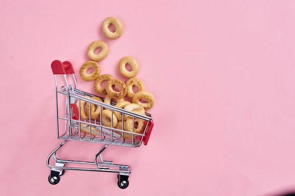 Piccolo shopping carrelli supermercato shopping rosa sfondo — Foto Stock