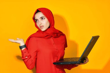 Dizüstü bilgisayarı olan neşeli bir kadın. Teknoloji duyguları sarı arka plan.