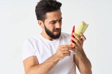 Elinde sebzelerle sakallı bir adam. Sıcak biberli mısır.