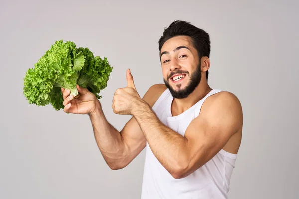 L'homme joyeux feuilles de laitue aliments sains posant — Photo