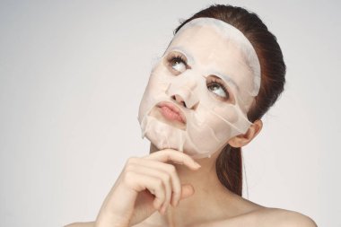 Güzel bir kadın çıplak omuzlarıyla maske takar.