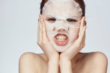 Güzel bir kadın çıplak omuzlarıyla maske takar.