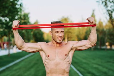 Parkın spor salonunda şişkin vücutlu atletik bir adam.