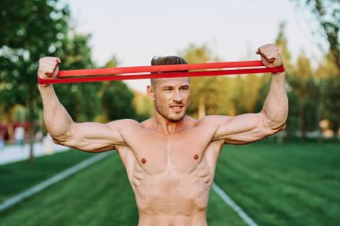 Parkın spor salonunda şişkin vücutlu atletik bir adam.