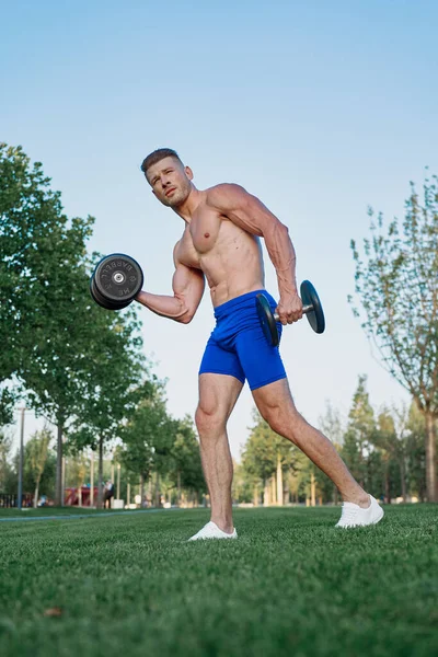 Parktaki sportif adam Crossfit egzersizi yapıyor.