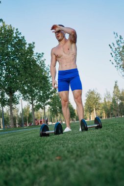 Parktaki sportif adam Crossfit egzersizi yapıyor.