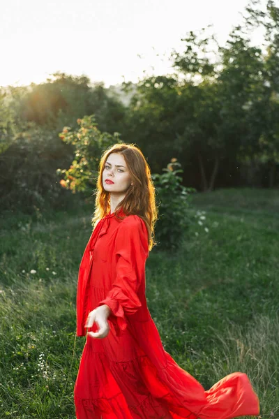 Attraktiv kvinna i röd klänning utomhus i frihet fält — Stockfoto