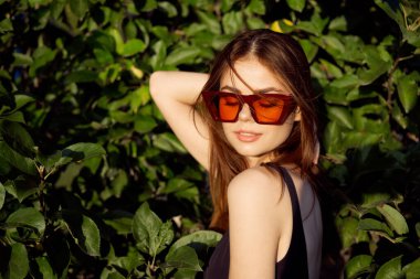 Siyah mayo giymiş güzel bir kadın moda yazında poz veriyor.