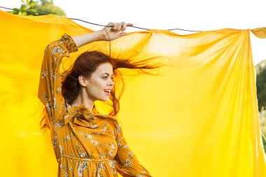 Elleri havada neşeli bir kadın poz veriyor.