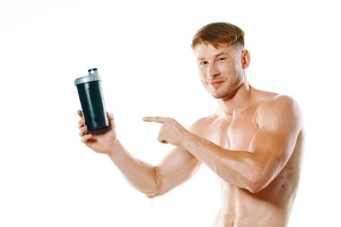 Şişirilmiş gövdesi olan atletik bir adam. Spor tükürüğü şişesi içiyor.