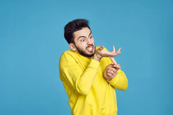 Homem em suéter amarelo problemas de saúde emoções fundo azul — Fotografia de Stock