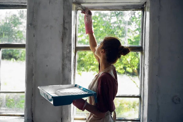 Kvinna målar fönster i huset inredning rum renovering — Stockfoto