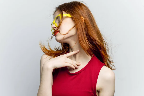 Mujer emocional en vestido rojo gafas amarillas posando Imágenes de stock libres de derechos