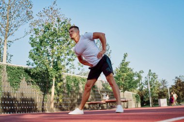 Adam dışarıda oyun sahasında egzersiz yapıyor.