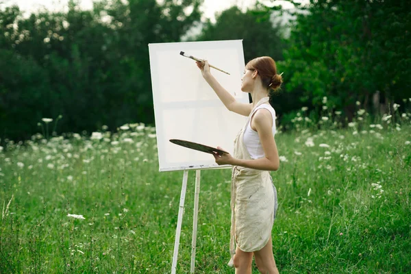 Žena umělec maluje na stojan v přírodě krajina — Stock fotografie