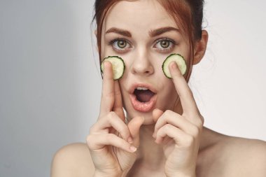 Salatalıklı, çıplak omuzlu neşeli kadın cilt bakımı kozmetolojisi.