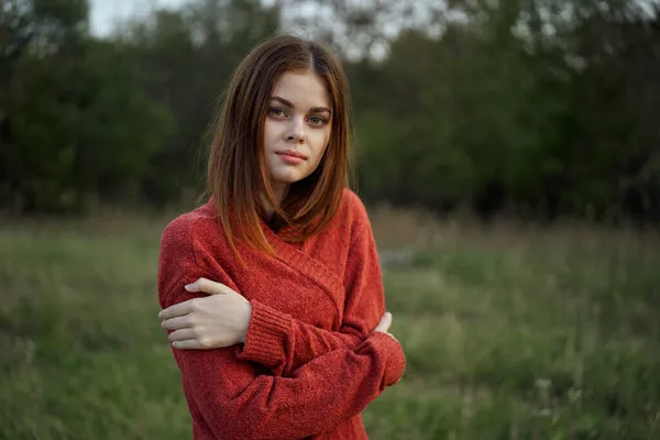 Γυναίκα σε ένα κόκκινο πουλόβερ σε εξωτερικούς χώρους στον τομέα της φύσης υπόλοιπο — Φωτογραφία Αρχείου