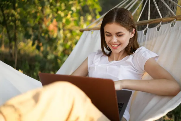 Kobiety na zewnątrz leży w hamaku z laptopem freelance internet — Zdjęcie stockowe