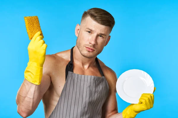 Mann in Schürze reinigt Geschirrspüler blauen Hintergrund — Stockfoto
