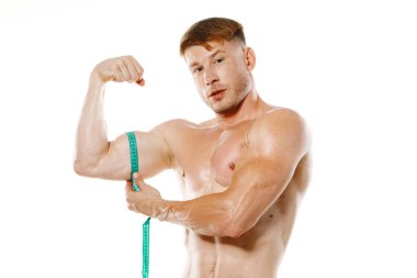 Atletik adam, mezura kas egzersizi yapıyor.