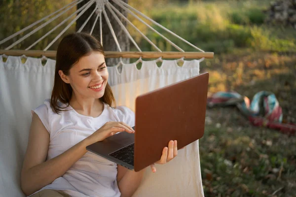 Kobieta z laptopem i leży w hamaku wakacje natura freelance — Zdjęcie stockowe