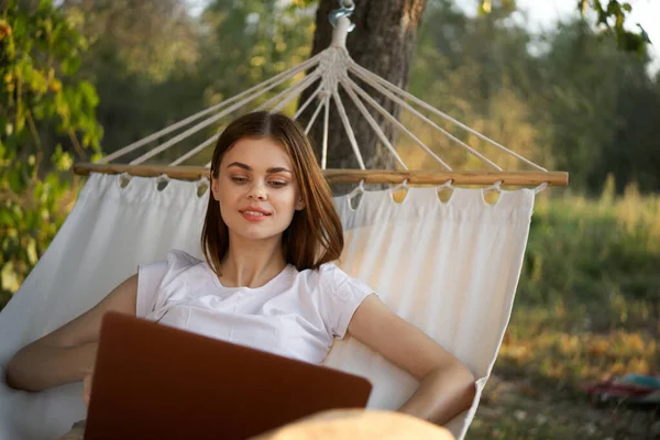 Vrouw met laptop en ligt in een hangmat vakantie natuur freelance — Stockfoto