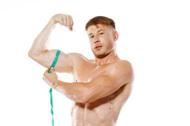 Atletik adam, mezura kas egzersizi yapıyor.