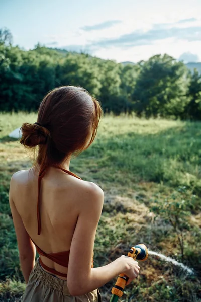 Mujer riego plantas en el jardín naturaleza crecimiento —  Fotos de Stock