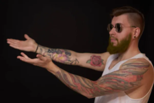 Man met baard in wit t-shirt met tatoeages op zijn armen poserende bullebak — Stockfoto