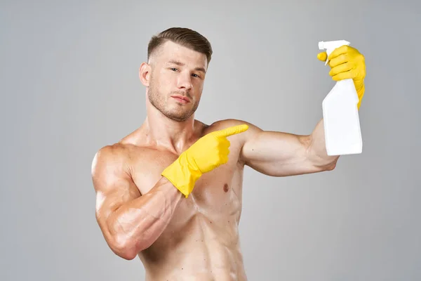 Pompato fino uomo posa con detergente in guanti di gomma — Foto Stock