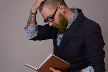 Elinde not defteri olan ceketli bir yönetici.