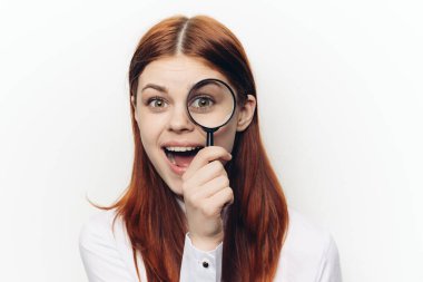 Yüzünde büyüteçle yüzünü buruşturan güzel bir kadın.