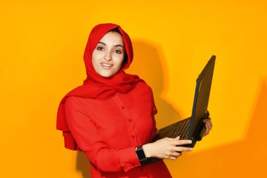 Dizüstü bilgisayarı olan neşeli bir kadın. Teknoloji duyguları sarı arka plan.