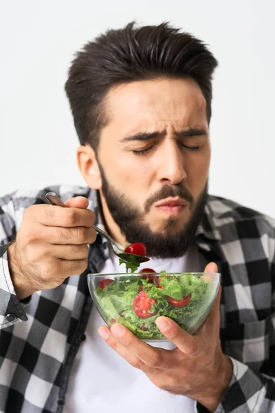 Uomo in camicia a quadri mangiare insalata cibo sano — Foto Stock