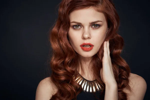 Atraente mulher ruiva em um vestido preto penteado fundo escuro — Fotografia de Stock